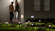 An assortment of Ring Smart Lighting products lighting up a homeowner's front yard at night.